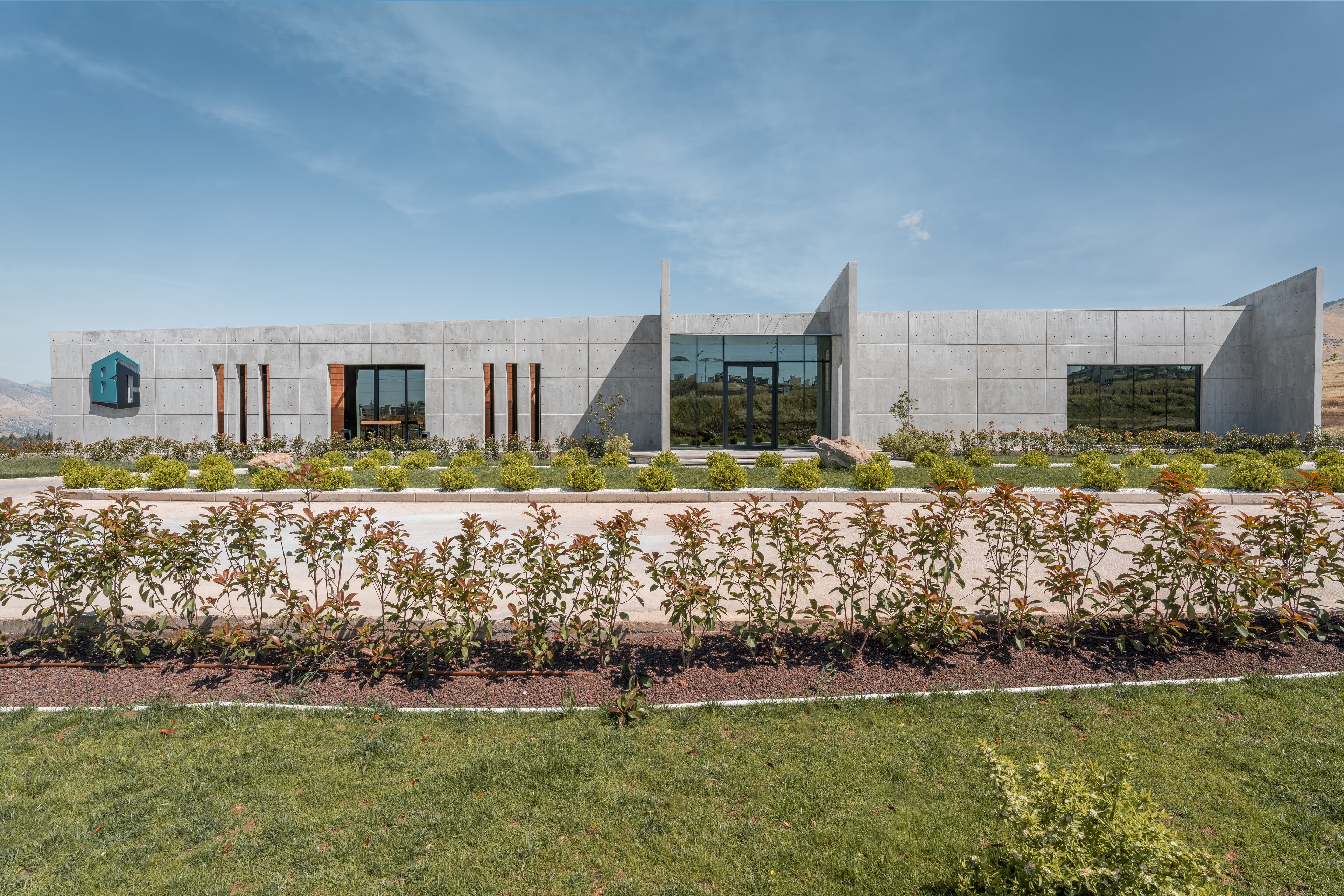 The Bahadin Concrete office: a long, low concrete building behind landscaped gardens