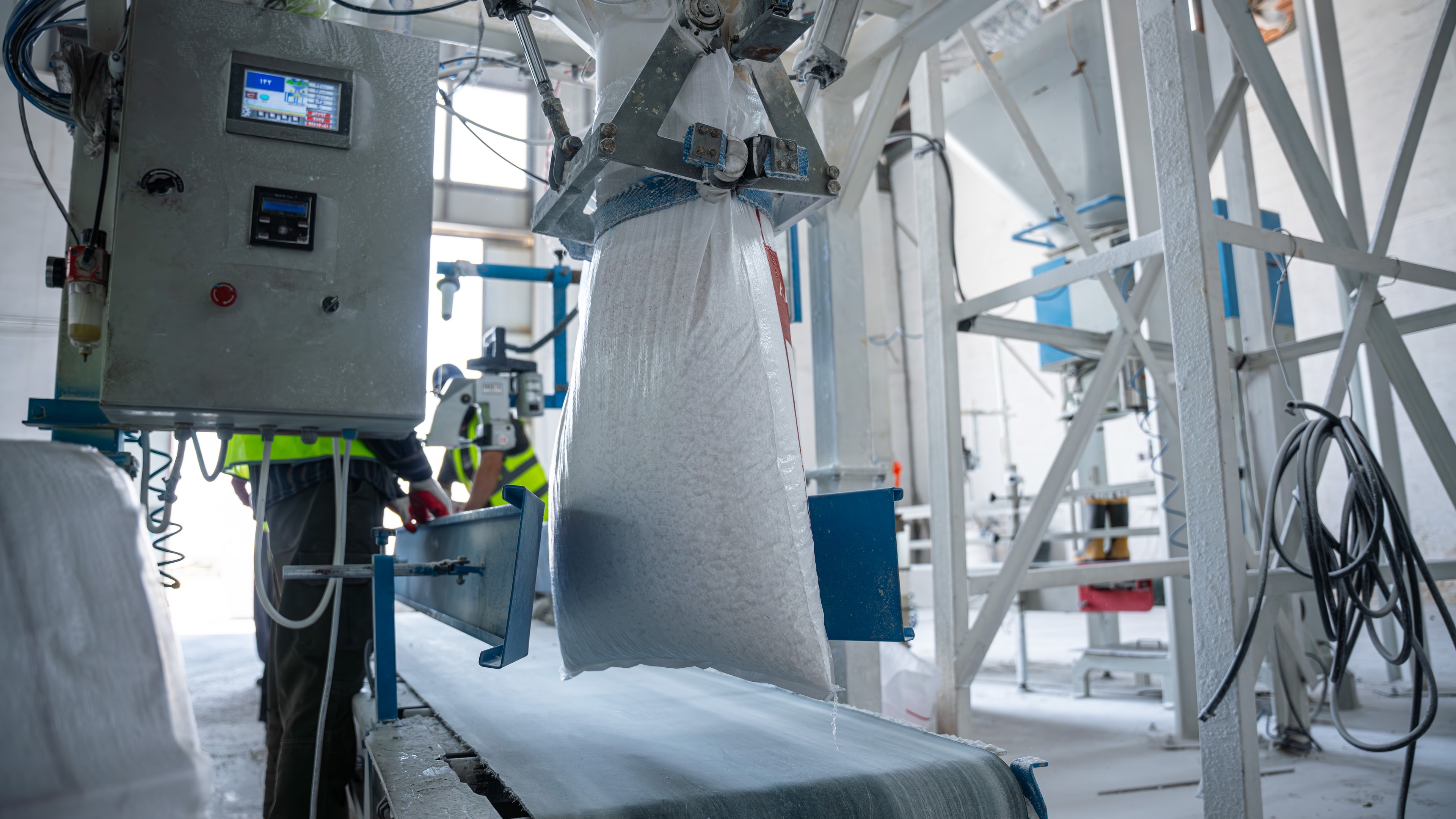 A bulk bag filling at the bagging line, a worker at its controls