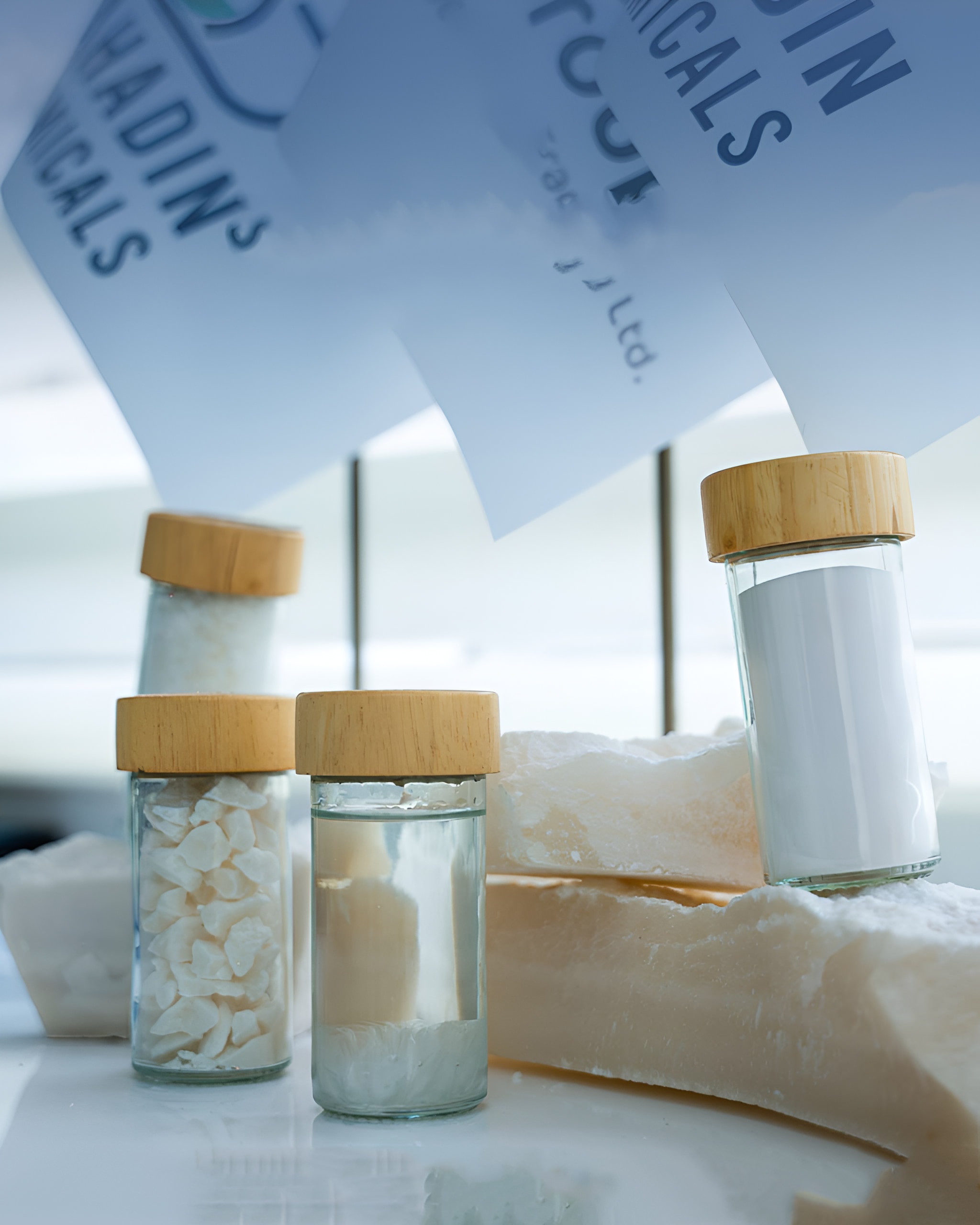 Sample jars of aluminium sulfate in front of Bahadin Chemicals bags